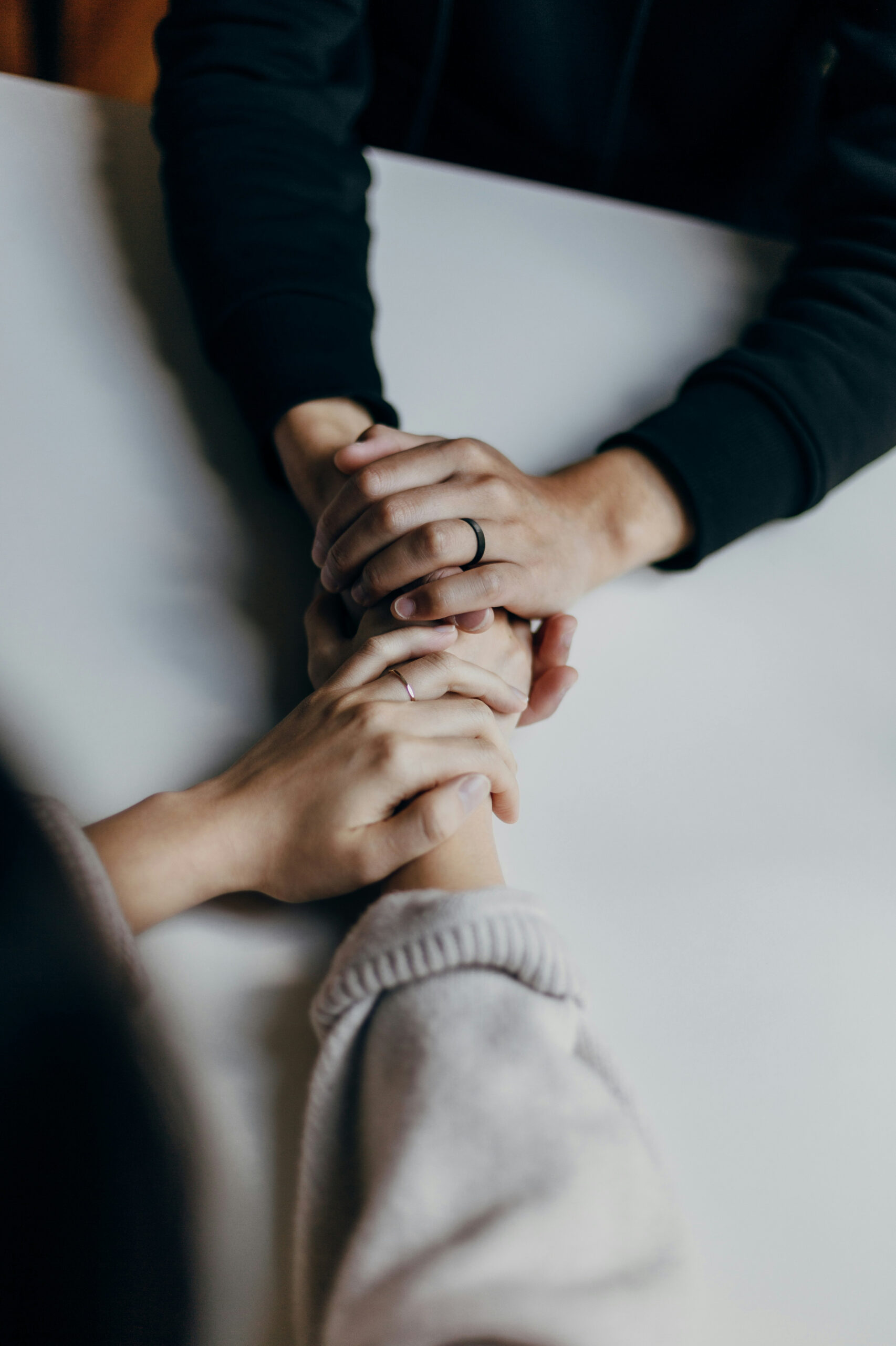 Two people holding each others hands Two people holding each other’s hands in a comforting gesture