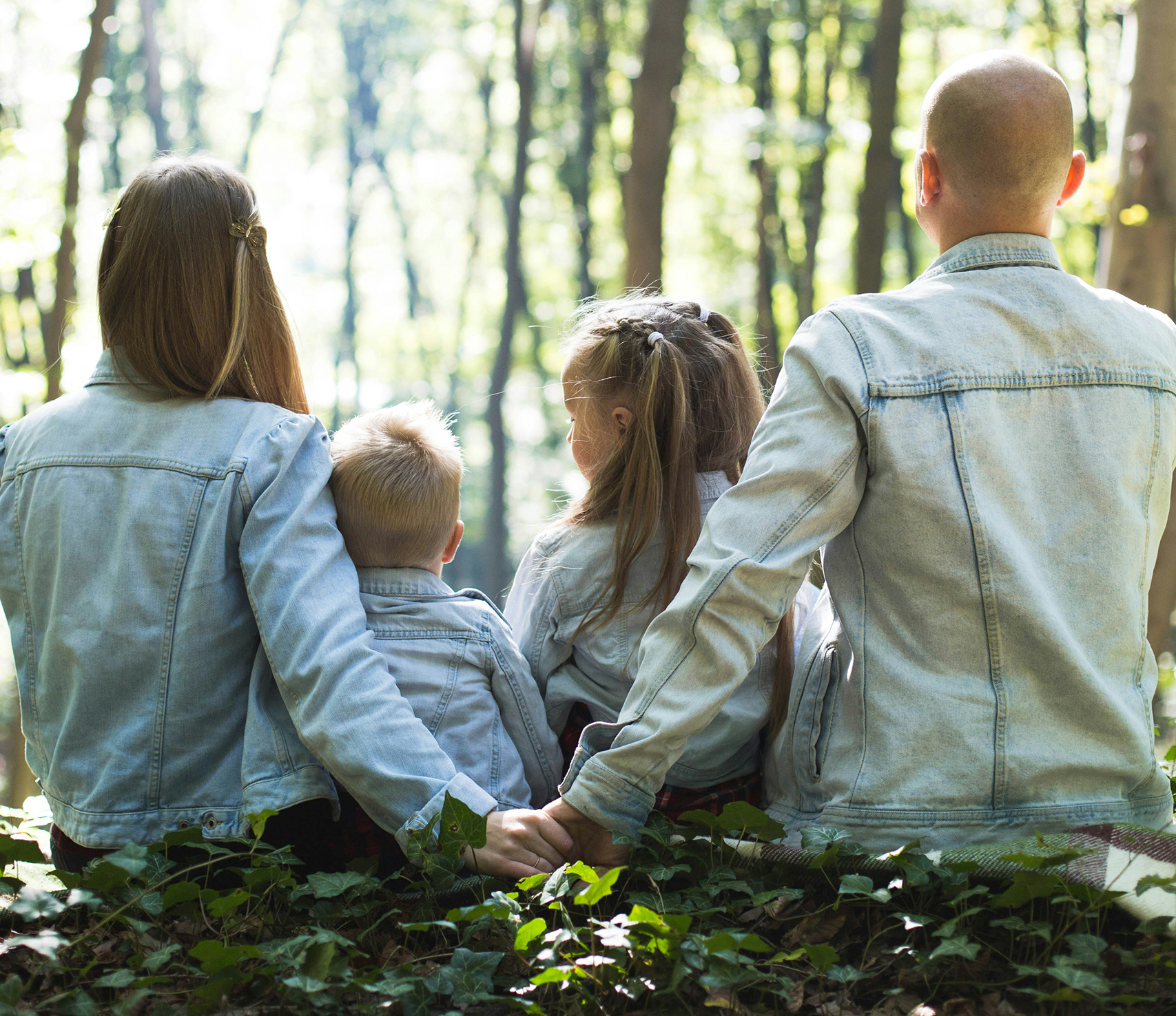 Four people - two adults and two children in the woods