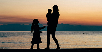 A family standing with the sea in the background